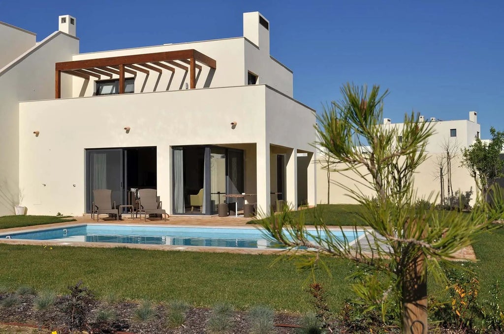 Luxurious wooden family villa at Martinhal Sagres Resort, featuring modern design, expansive windows, and scenic coastal Portugal landscape in background.