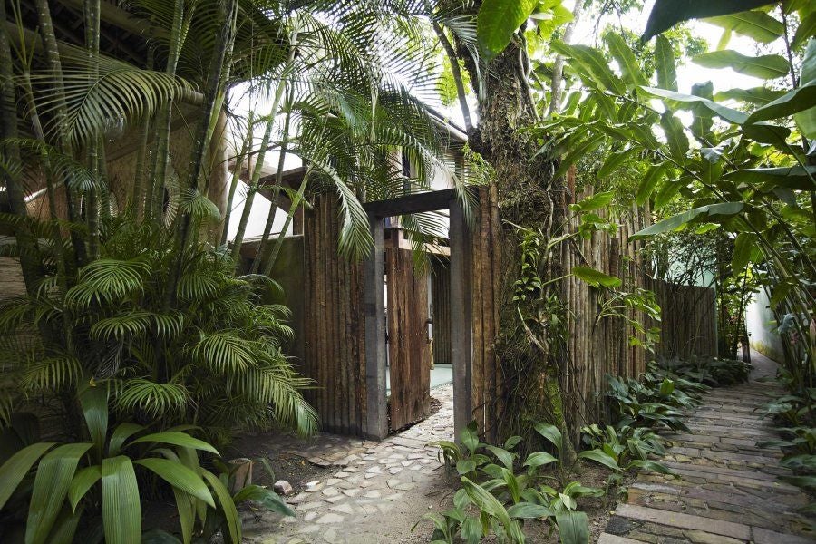 Luxurious wooden terrace overlooking lush tropical scenery at UXUA Casa Hotel, featuring elegant seating and panoramic views of Brazilian coastline