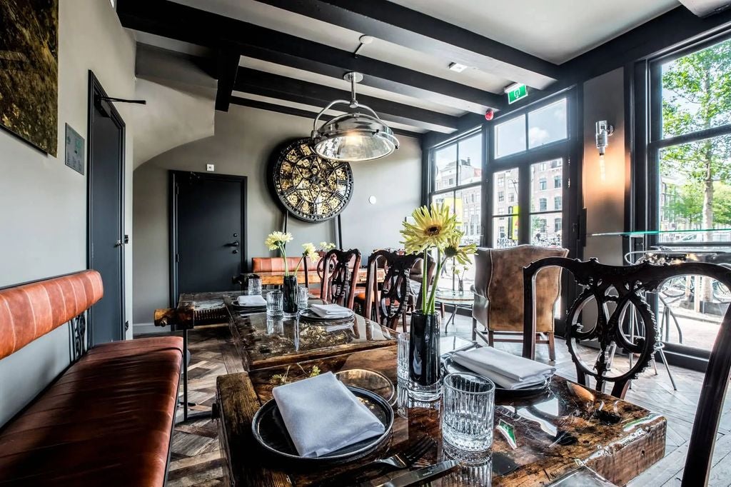 Elegant boutique canal house hotel in Amsterdam with classic Dutch facade, featuring ornate brickwork and traditional stepped gables