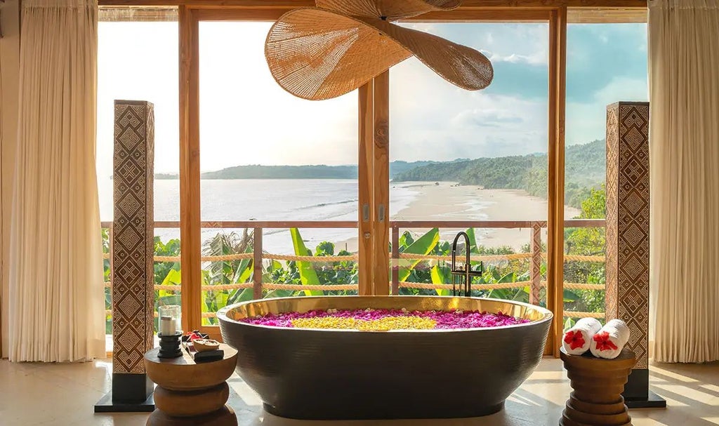 Luxurious wooden villa overlooking lush tropical landscape, private infinity pool, traditional Indonesian design, sunset views at NIHI Sumba resort