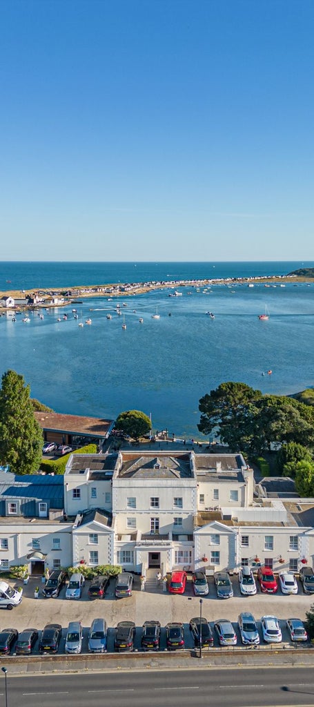 Luxurious waterfront hotel with modern architecture, expansive windows overlooking Southampton's harbor, featuring sleek design and elegant maritime ambiance