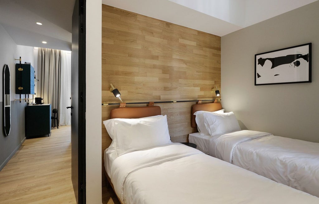 Spacious family room with minimalist design, crisp white bedding, modern wooden furniture, soft natural light, and elegant city view in Thessaloniki hotel.