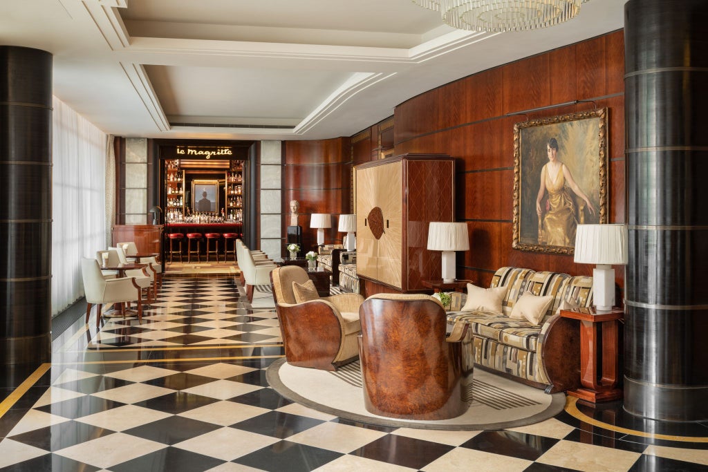 Elegant Art Deco lobby of luxury hotel with marble floors, golden accents, plush seating, and chandelier showcasing refined Mayfair hospitality design