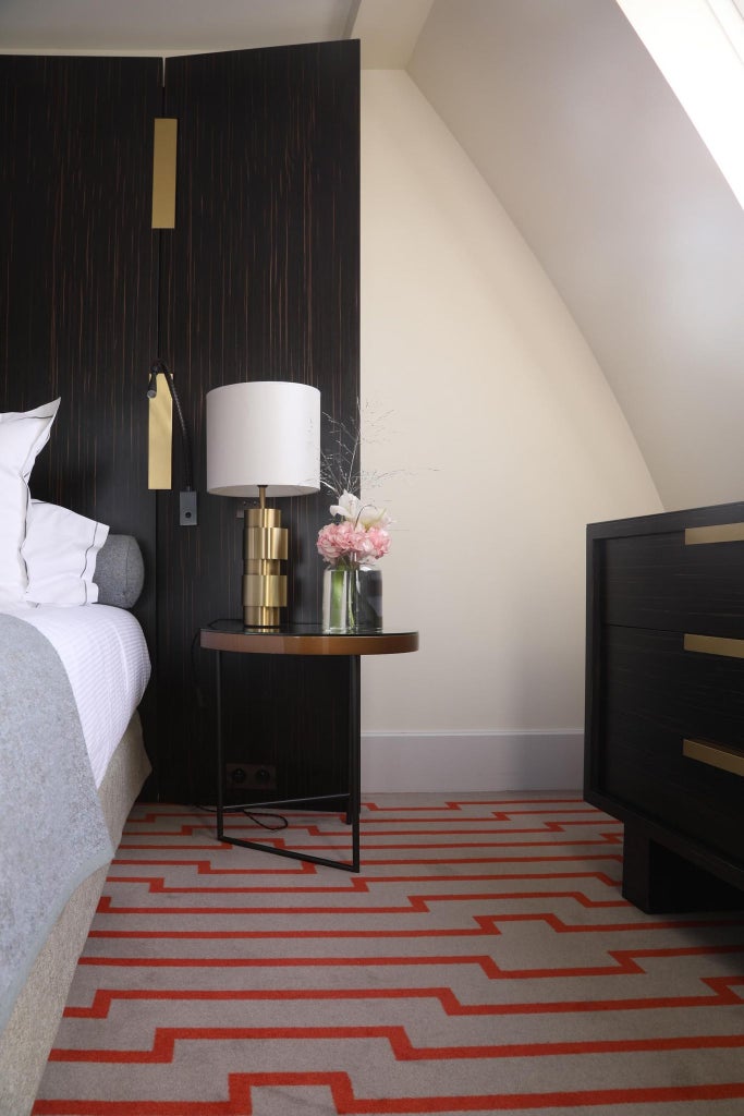 Elegant Paris hotel room with soft neutral tones, plush king bed, modern marble bathroom, and large windows overlooking Saint-Germain-des-Prés district