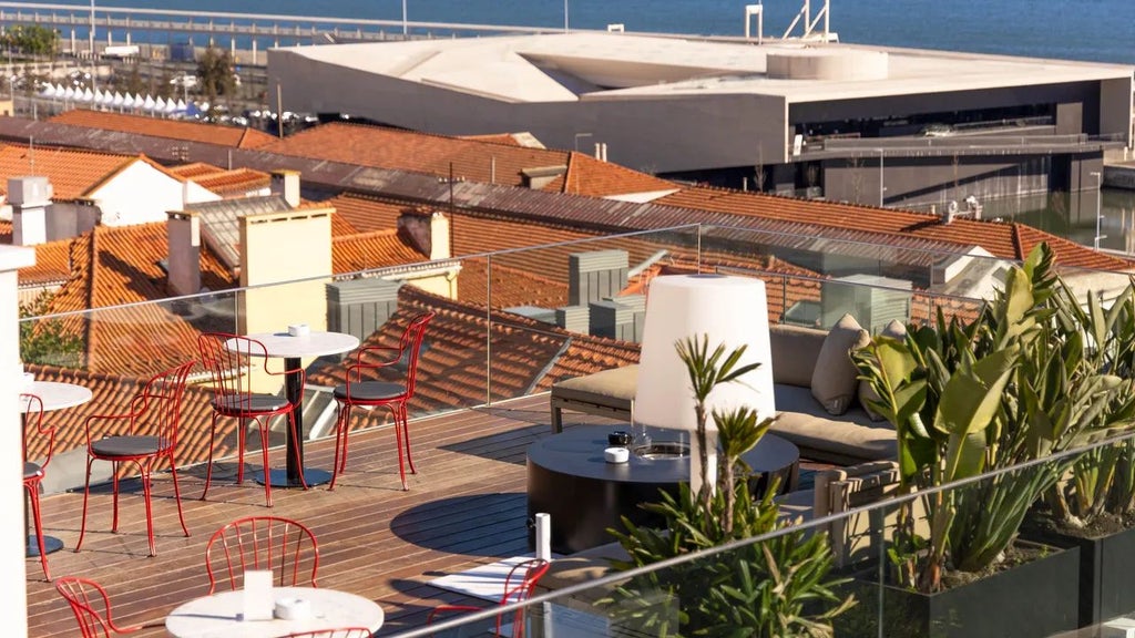 Elegant boutique hotel nestled in Lisbon's historic Alfama district, featuring terracotta rooftops, traditional architecture, and panoramic city views at sunset