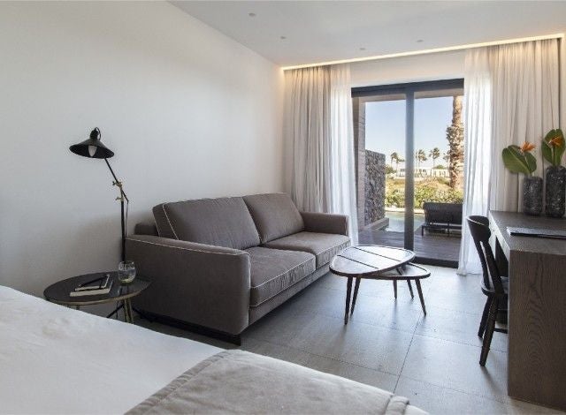 Elegant modern deluxe double room at Lango Design Hotel & Spa, featuring minimalist decor, crisp white linens, and panoramic Grecian coastal views