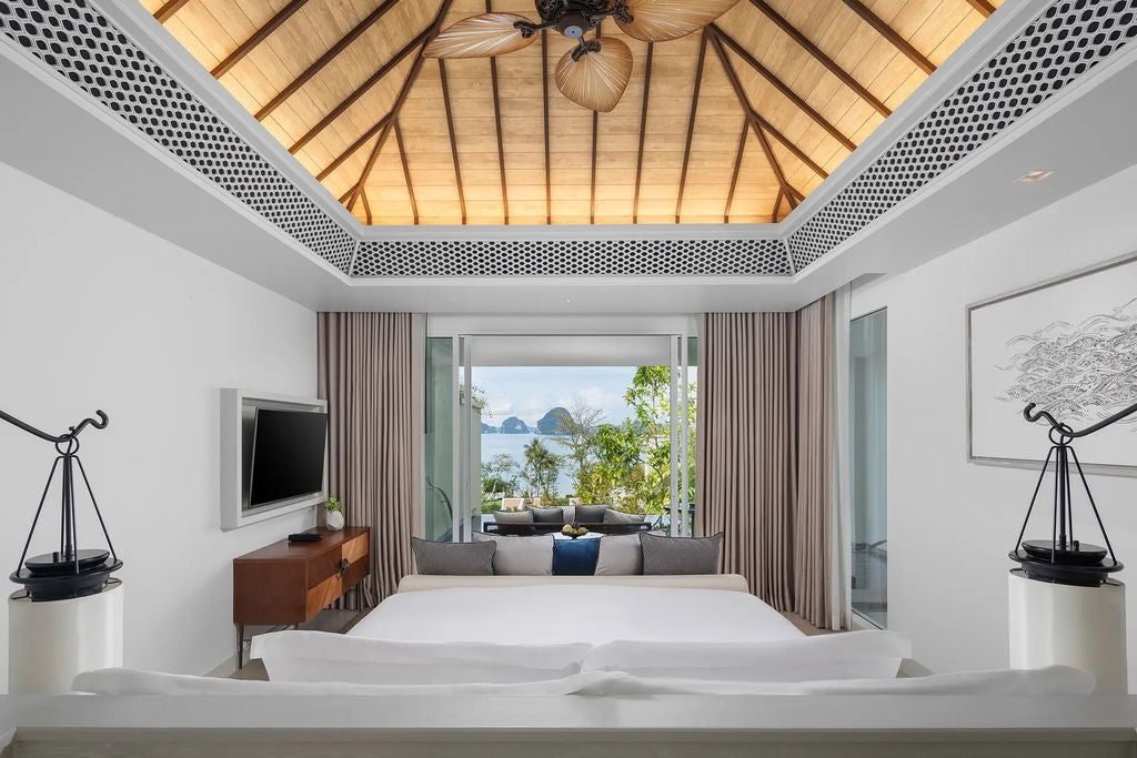 Spacious luxury suite with private infinity pool overlooking Andaman Sea, featuring modern Thai decor and floor-to-ceiling windows