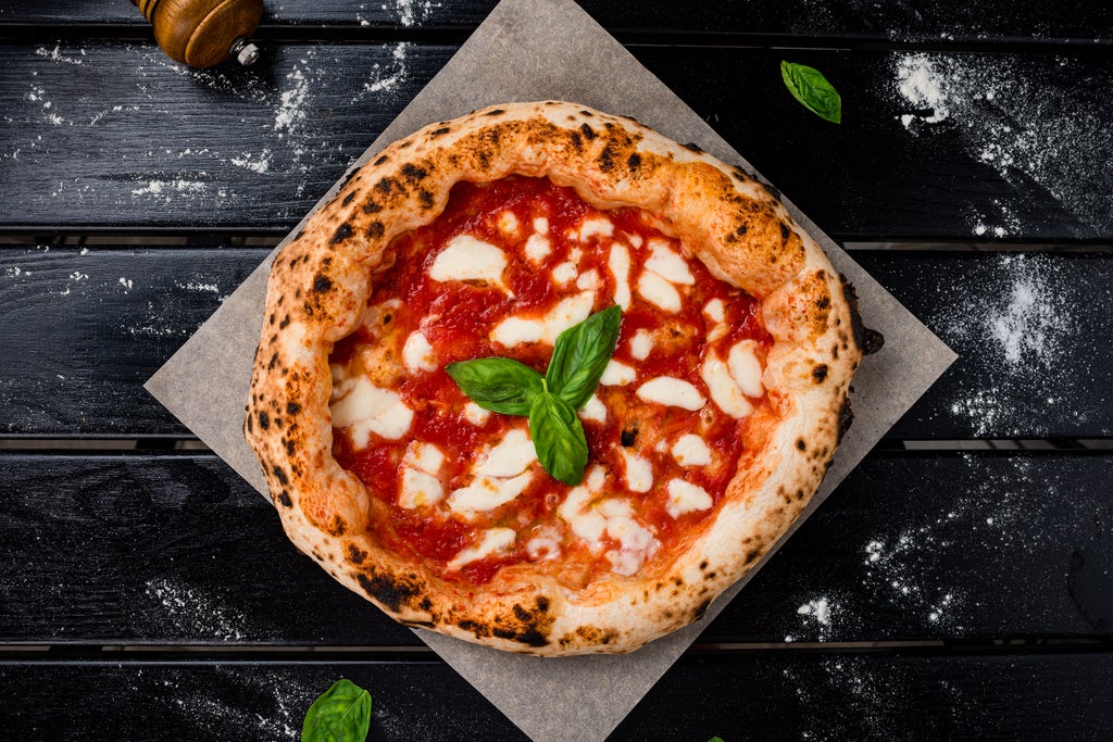 Local guide serving authentic Napoli pizza and wine at a rustic courtyard restaurant with exposed brick walls and hanging vines