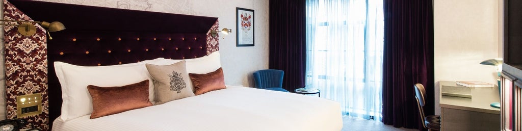 Elegant Deluxe hotel room at Vintry & Mercer with plush king bed, rich wooden furnishings, soft neutral color palette, and sophisticated urban design