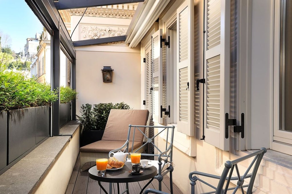 Elegant boutique hotel facade in Rome with ornate balconies, classical architecture, and warm lighting illuminating its stone exterior