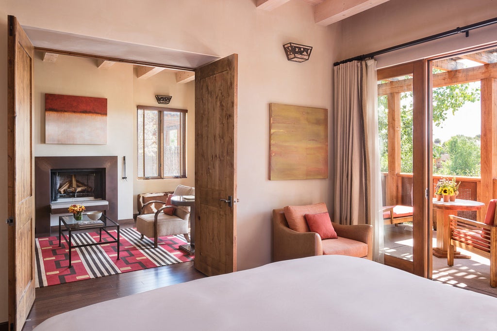 Adobe-style luxury resort with earth-toned stucco walls, private balconies and mountain views in Santa Fe's desert landscape