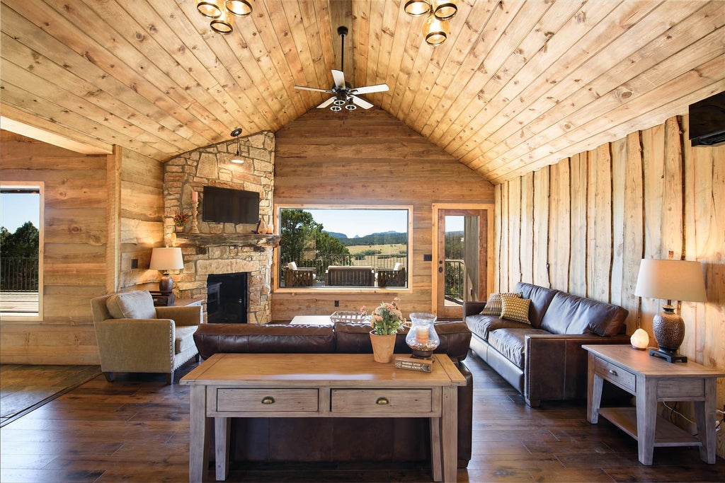 Rustic wooden lodge room with plush king bed, panoramic mountain views, warm earth tones, and elegant western-inspired decor at scenset Mountain Ranch