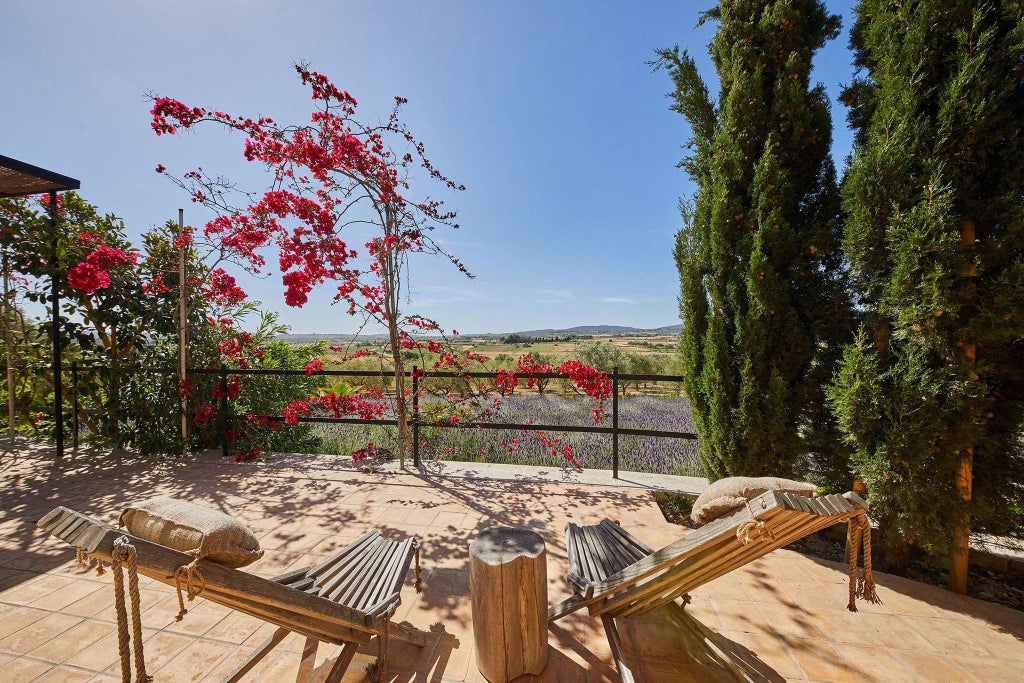 Elegant stone country villa with whitewashed walls and rustic wooden beams, nestled among lavender gardens in rural Mallorca