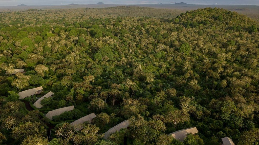 Luxurious eco-lodge nestled in Galapagos highlands, with minimalist safari-style tent cabins overlooking lush volcanic landscape and distant Pacific Ocean.