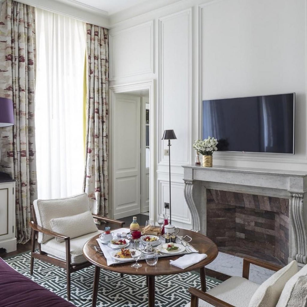 Elegant Parisian hotel interior with luxurious cream-colored furnishings, sophisticated design, and chic French architectural details creating a refined atmosphere