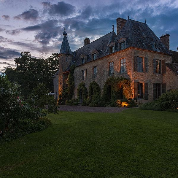 Historic 18th-century French château hotel with elegant limestone facade, manicured gardens, and classic architectural details in rural Loire Valley landscape.