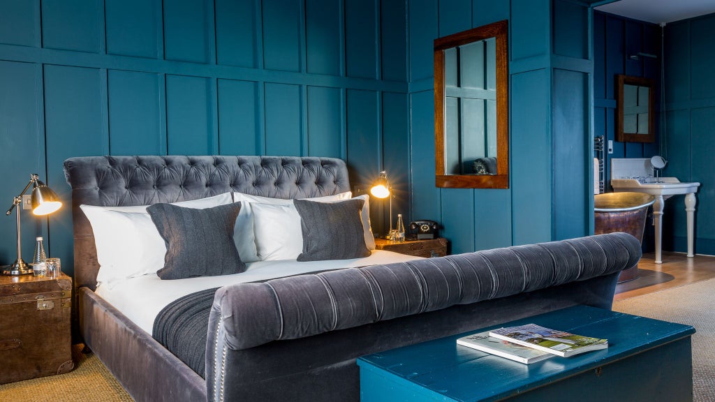 Spacious modern loft suite with elegant king bed, panoramic city views, luxe neutral decor, and contemporary minimalist design in UK boutique hotel.