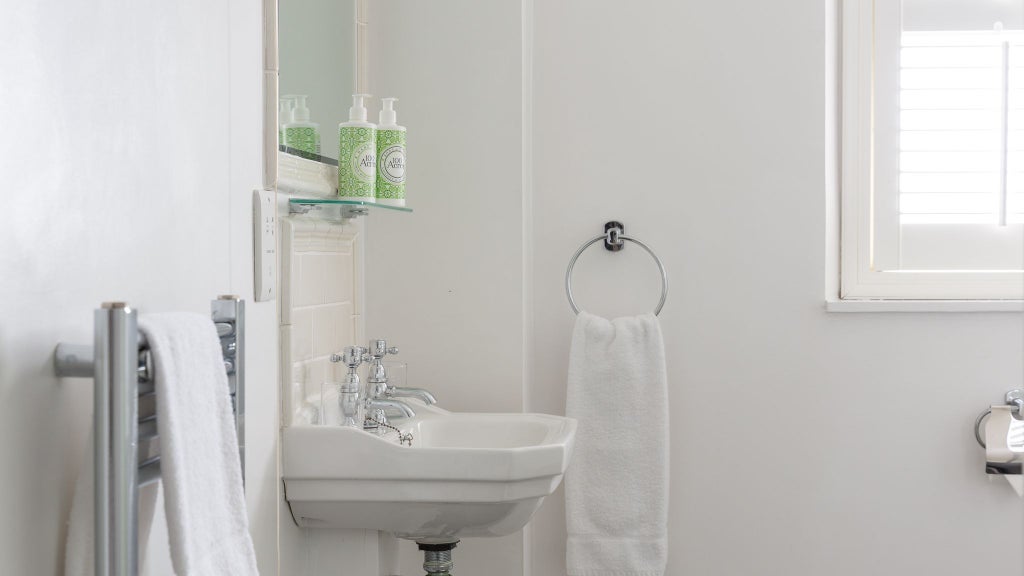 Elegant hotel room with modern shower, crisp white linens, and minimalist design in a contemporary UK accommodation with soft neutral tones