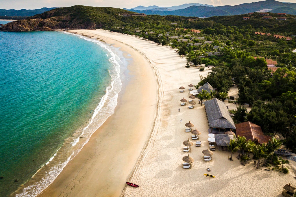 Secluded luxury villa with private infinity pool overlooking pristine Vietnamese coastline and lush tropical gardens at sunset