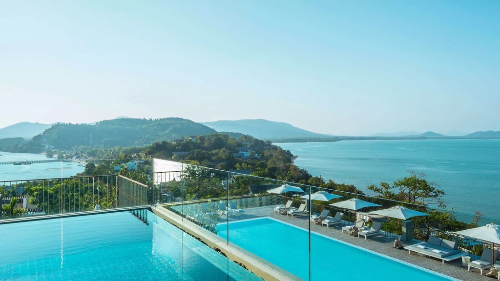 Luxurious COMO Point Yamu resort overlooking stunning Phang Nga Bay, with sleek modern architecture blending seamlessly into dramatic limestone cliff landscape