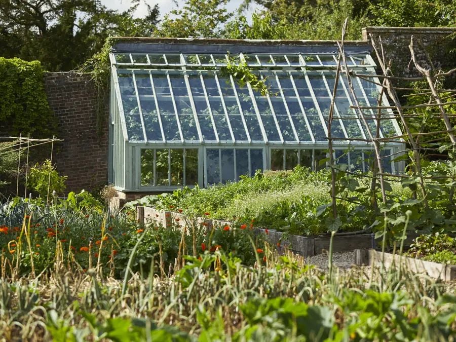 Rustic-chic country house hotel nestled in lush Somerset countryside, with stone walls, ivy-covered facade, and elegant garden terrace near Bath, UK