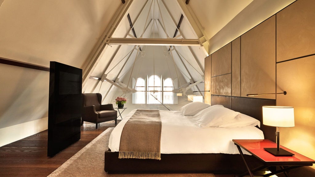 Spacious luxury suite with elegant design, blending modern furnishings and architectural details in Amsterdam's iconic Conservatorium Hotel.