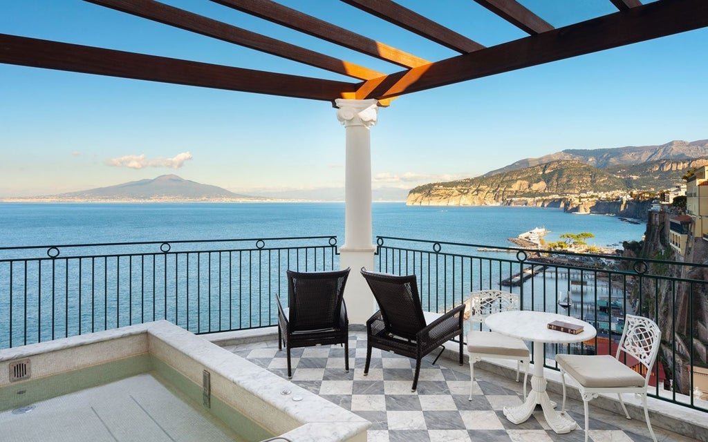 Luxurious cliffside hotel with panoramic views of the Sorrentine coastline, elegant Mediterranean architecture overlooking azure waters and verdant landscape