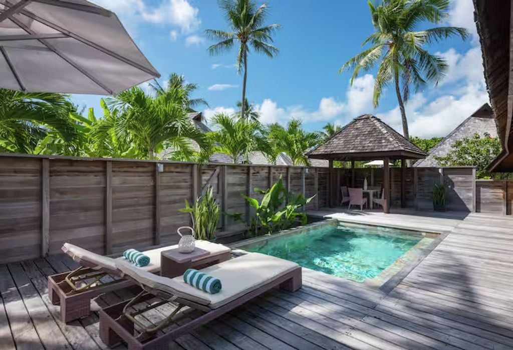 Luxurious king suite overlooking tropical garden, private infinity pool with wooden deck, plush loungers and breezy Polynesian decor