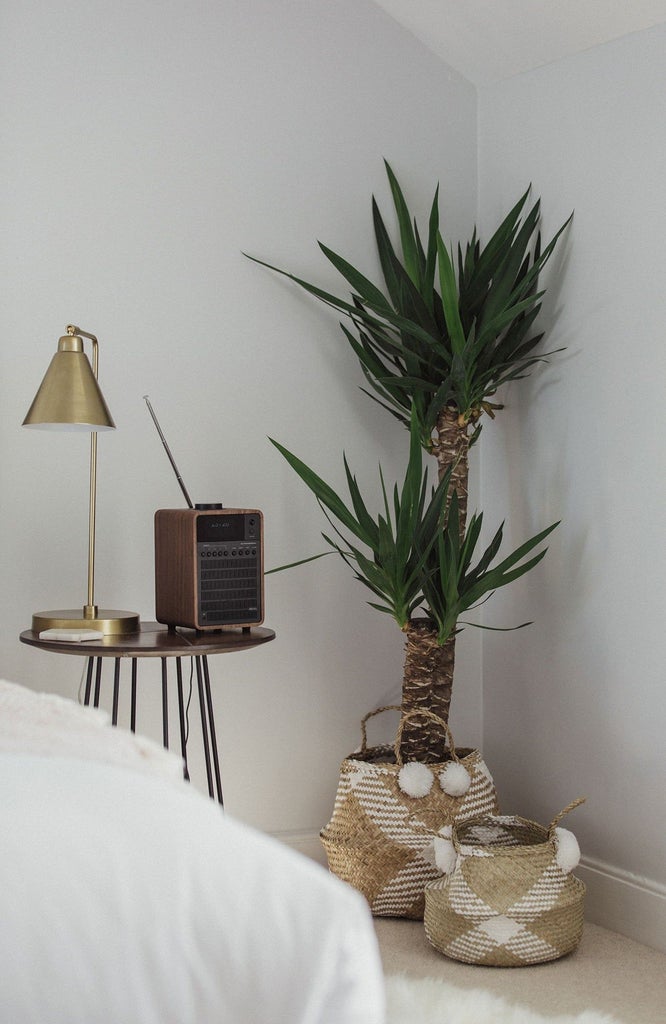 Luxurious hotel bedroom in soft neutral tones, featuring crisp white linens, elegant wooden furniture, and large windows with natural light in a boutique UK accommodation