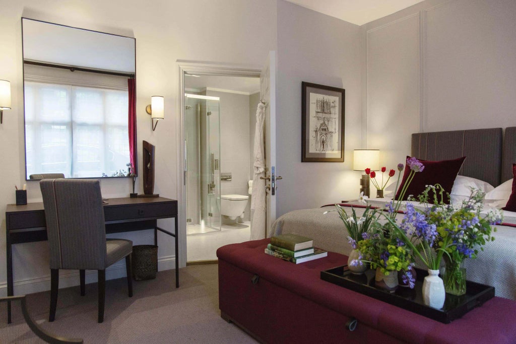 Elegant, spacious accessible hotel room with neutral color palette, modern furnishings, and wheelchair-friendly design at historic Old Parsonage Hotel in UK