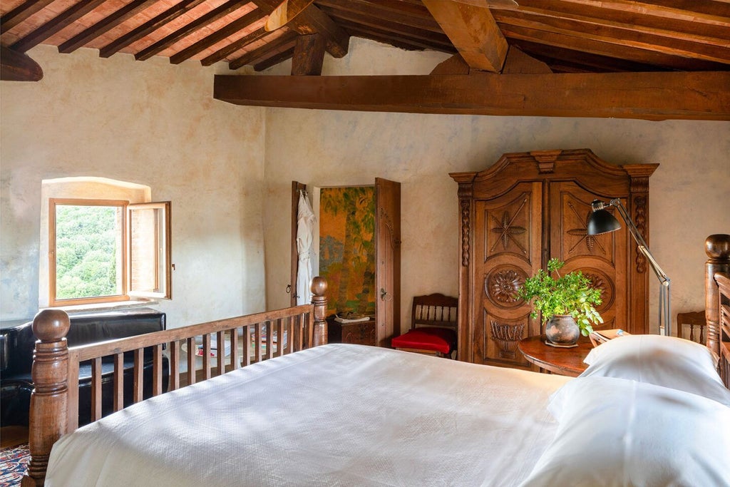 Elegant Tuscan suite with stone walls, antique furnishings, plush king bed, and panoramic views of rolling countryside at luxurious Castello di Vicarello resort