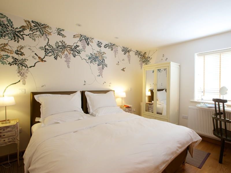 Elegant classic hotel room at Eckington Manor, featuring crisp white linens, plush furnishings, and warm wooden accents in a refined United Kingdom setting