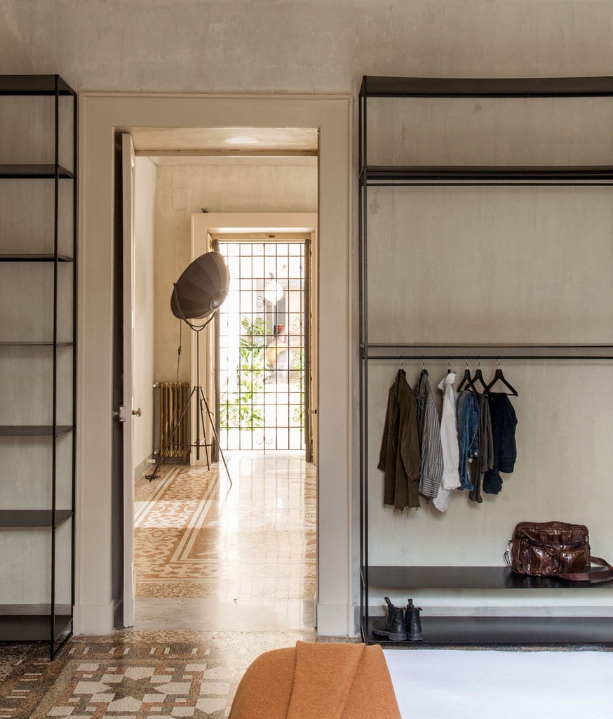 Elegant junior suite at Palazzo Daniele, featuring ornate marble floors, minimalist furnishings, and soft natural light in a historic Italian setting