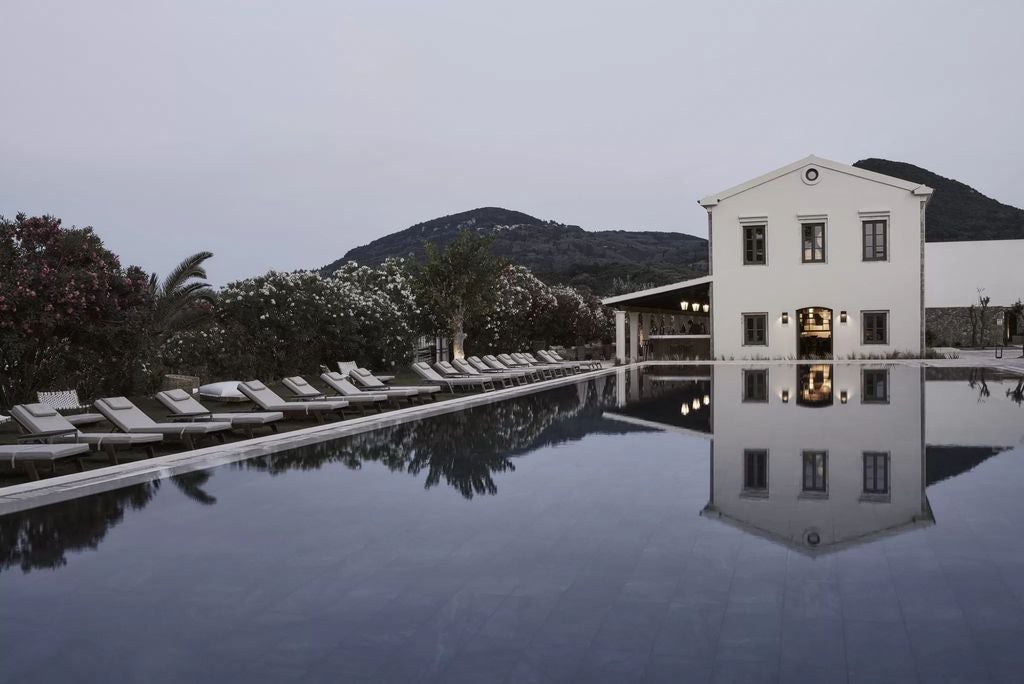 Elegant whitewashed suite with private plunge pool overlooking the Mediterranean Sea, featuring minimalist Greek design and sun loungers