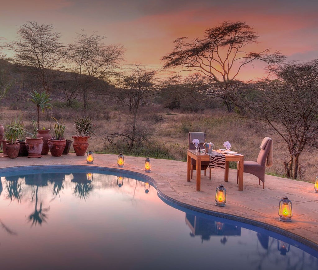 Luxurious safari lodge nestled in lush Kenyan hills, featuring stone walls, thatched roof, and expansive viewing deck overlooking wilderness