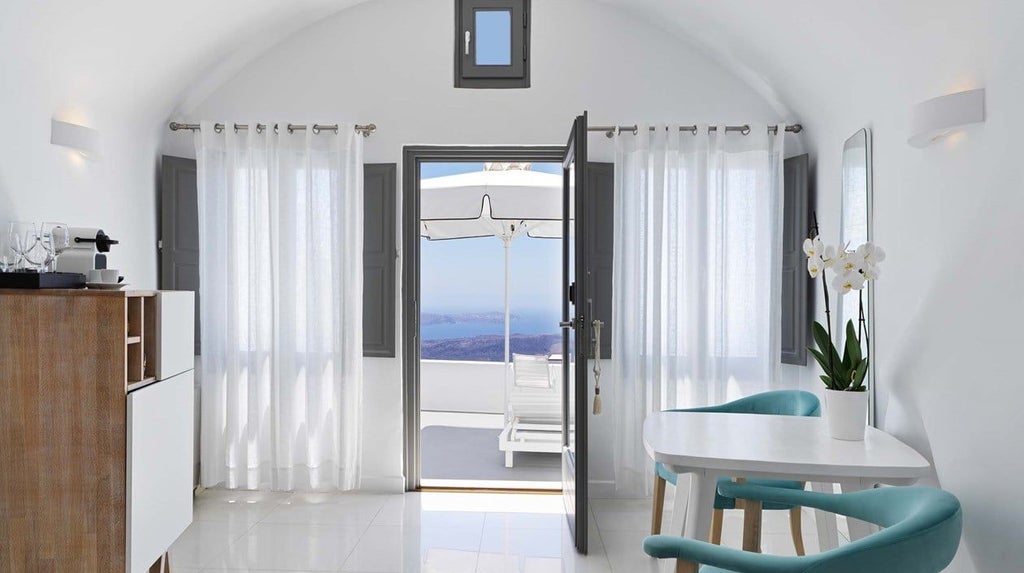 Luxurious Chromata Infinity Pool Suite overlooking Santorini's azure Aegean Sea, white-washed architecture, and pristine blue infinity pool at sunset