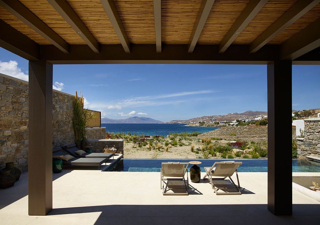 Luxurious one-bedroom villa in Mykonos with panoramic Aegean Sea view, private heated pool, and contemporary white minimalist design