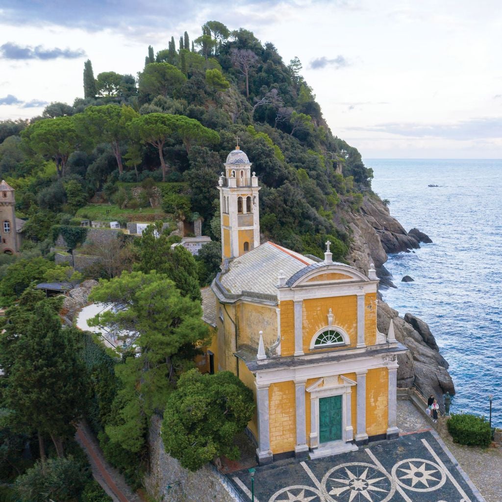 Crystal-clear turquoise harbor surrounded by vibrant pastel buildings, luxury yachts and fishing boats in Portofino's iconic Italian Riviera setting