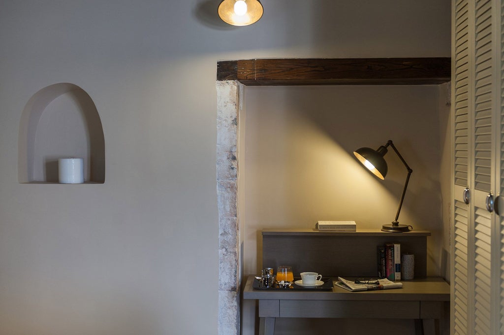 Elegant standard double room at Serenissima Boutique Hotel, featuring crisp white linens, minimalist decor, and warm wooden accents in a serene Greek setting