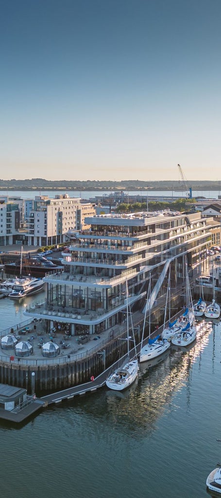 Luxurious waterfront hotel with modern glass facade overlooking Southampton harbour, featuring sleek architectural design and panoramic maritime views