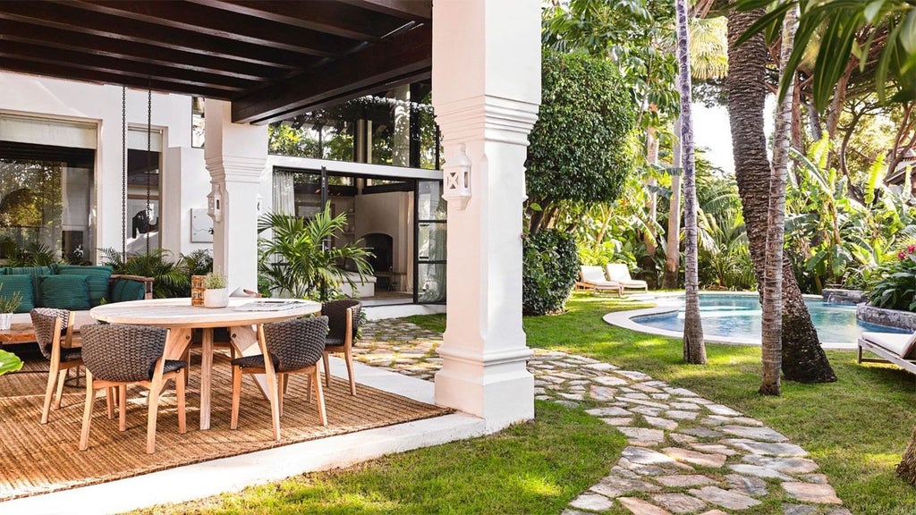 Elegant white-and-blue Mediterranean suite with plush king bed, ocean view balcony, and contemporary coastal Spanish design in Marbella Club Hotel