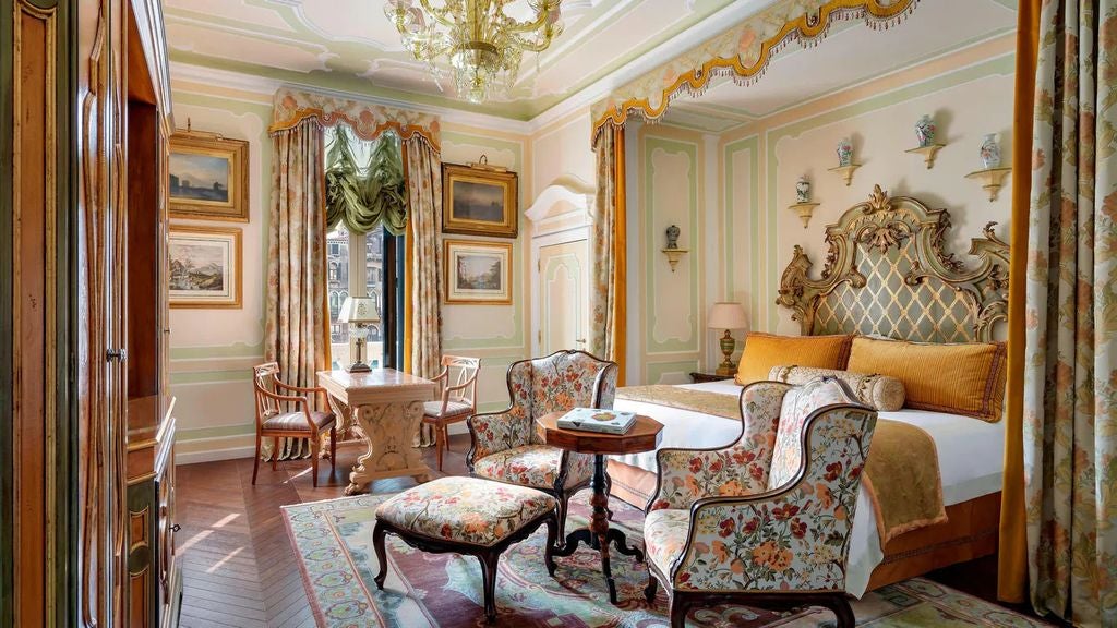 Opulent presidential suite with ornate Venetian furnishings, crystal chandeliers, antique artwork, and panoramic Grand Canal views