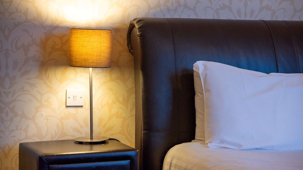 Elegant double room with plush white bedding, modern neutral decor, floor-to-ceiling windows overlooking cityscape in a luxury United Kingdom hotel room