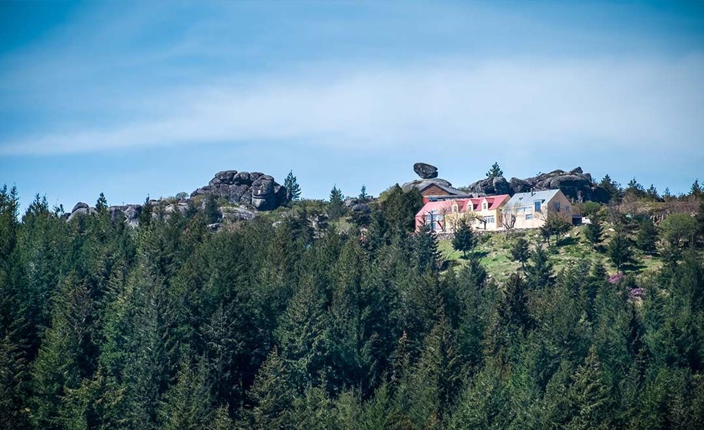 Mountain retreat with contemporary white architecture nestled in rustic Portuguese landscape, featuring sleek design and panoramic alpine views of Serra da Estrela.