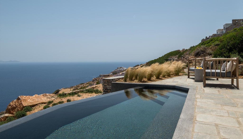 Minimalist white Greek island hotel room with panoramic Aegean Sea view, sleek design, elegant white linens, and modern minimalist furnishings at Verina Astra