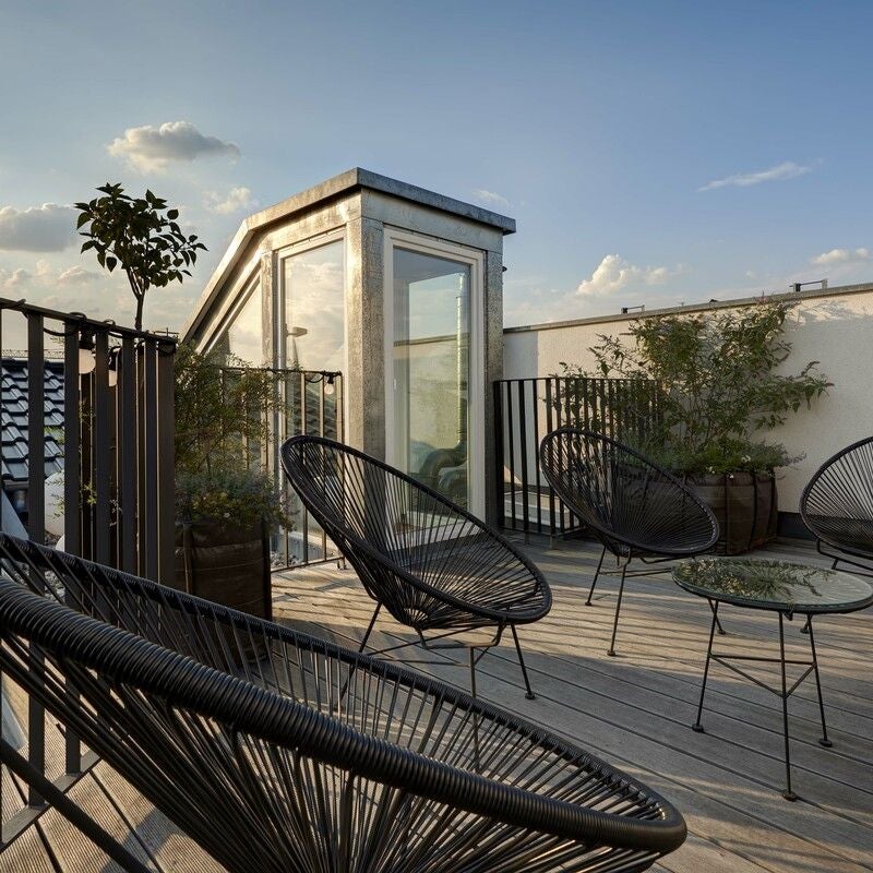 Luxurious penthouse suite with modern minimalist design, floor-to-ceiling windows, sleek furniture, and panoramic urban skyline view in Germany