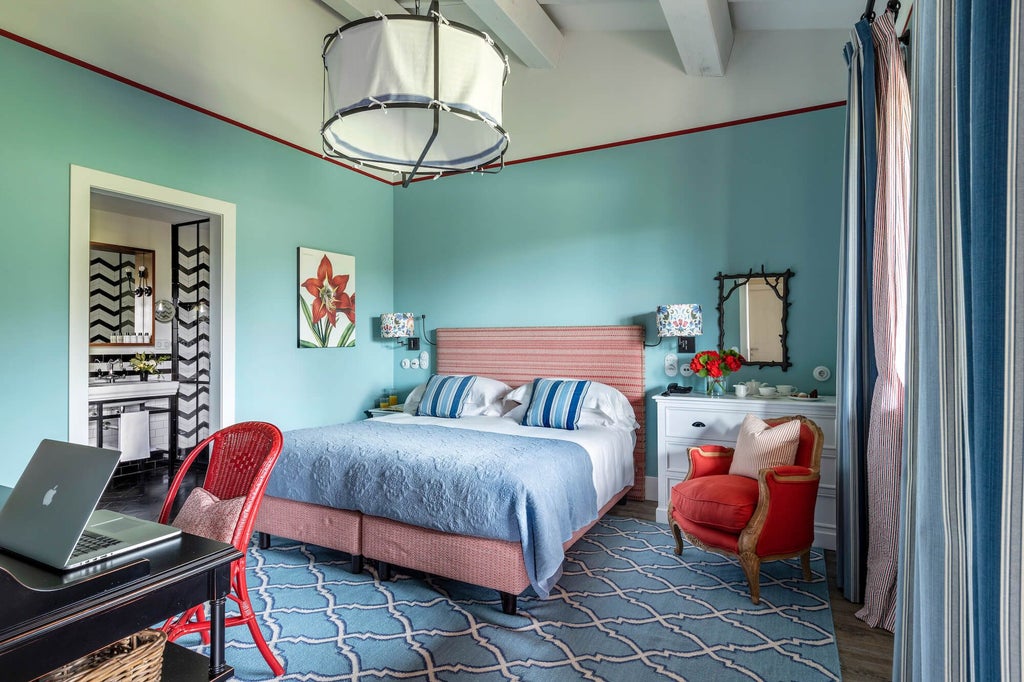 Elegant garden suite at Locanda Rossa, featuring rustic stone walls, plush white bedding, and soft natural light streaming through arched windows in Tuscany.