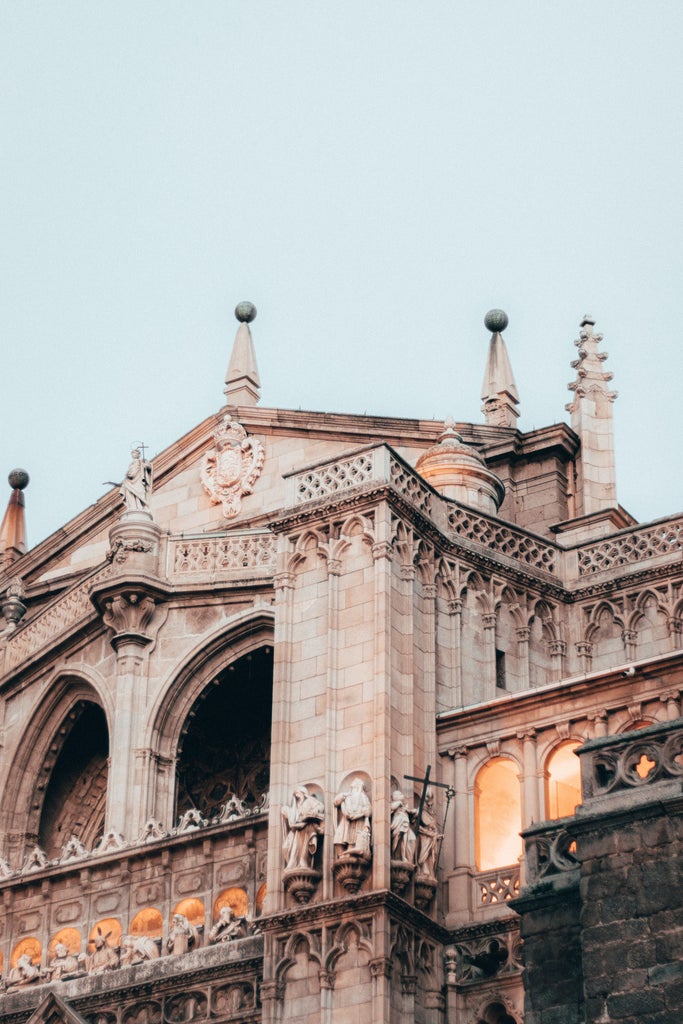 Historic Toledo cathedral with golden sunlight, medieval stone architecture, and panoramic Spanish landscape highlighting royal architectural elegance