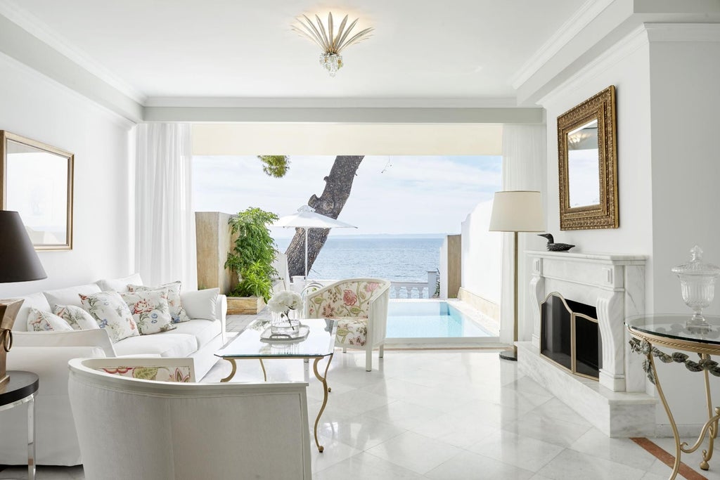 Luxurious executive pool suite overlooking azure Aegean waters, with elegant white interiors, private infinity pool, and minimalist contemporary design