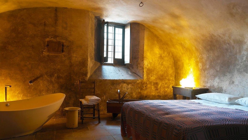 Rustic stone-walled dining area in historic Italian hotel, wooden table, vintage wine bottles, warm candlelight, traditional Abruzzo architectural charm